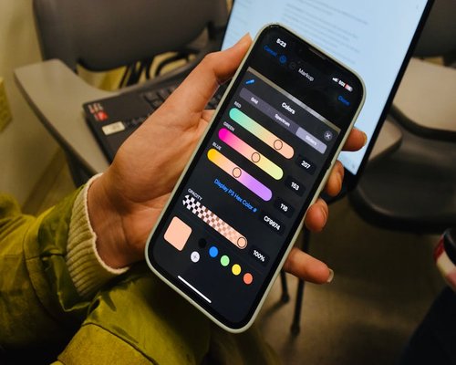 Hand adjusting the brightness settings on a smartphone